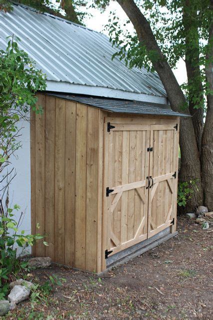 A Wooden Storage Shed Sitting Next To A Tree