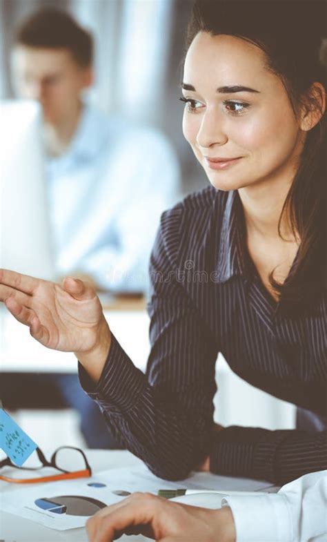 Business Woman And Man Discussing Questions While Using Computer At