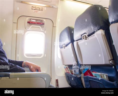 Männlichen Passagier Sitzt Im Notausgang Im Flugzeug Stockfotografie