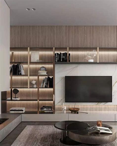 A Living Room With A Large Tv Mounted On The Wall And Bookshelves Behind It