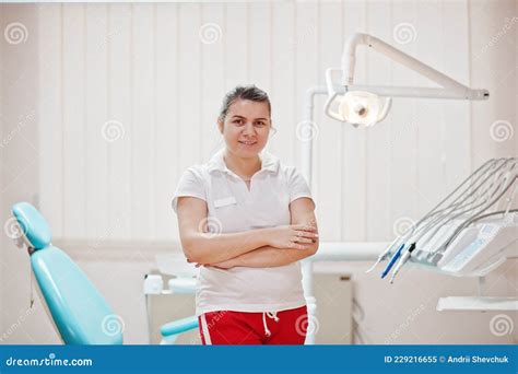 Portrait Of Female Dentist Woman Crossed Arms Standing In Her Dentistry