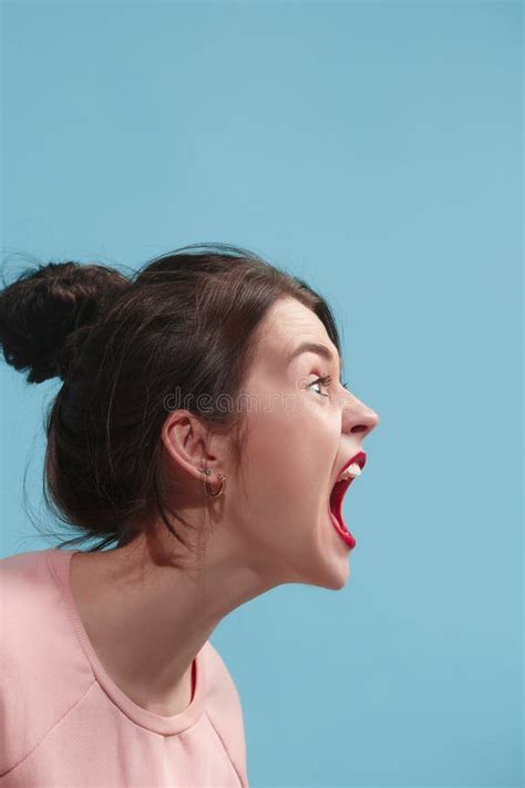 The Young Emotional Angry Woman Screaming On Blue Studio Background