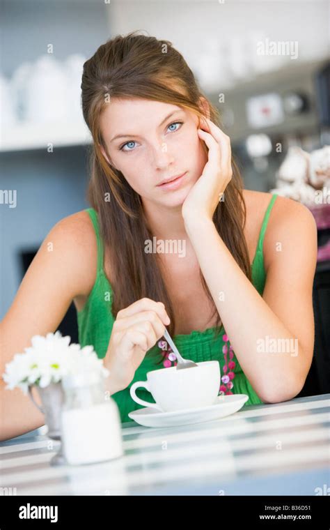Young Woman Sitting At A Table Drinking Tea Stock Photo Alamy