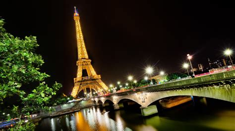 Paris Eiffel Tower With Yellow Lights And Bridge With Glittering Lights
