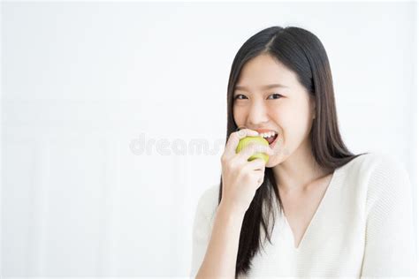 Dents Fortes De Jeune De Femme De Morsure De Vert Exposition Asiatique De Pomme Photo Stock