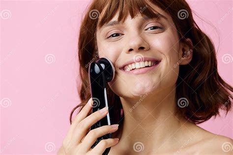 A Sweet Relaxed Woman Stands On A Pink Background And Massages Her