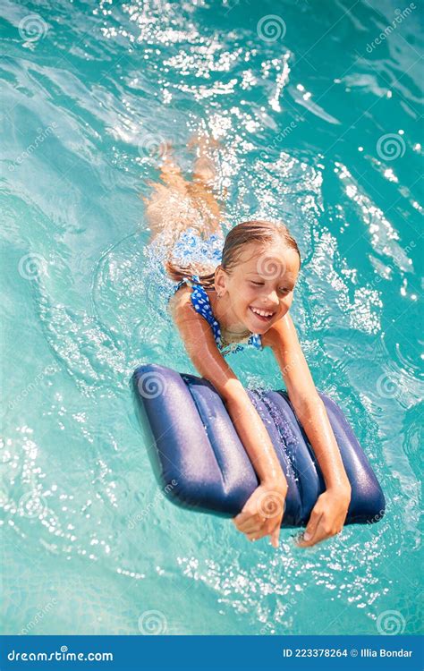 Happy Little Girl Having Fun In The Swimming Pool Dives And Swim