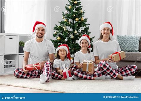 Feliz Familia Abriendo Regalos De Navidad En Casa Foto De Archivo