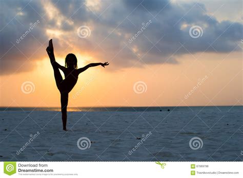 Silhouette Of Adorable Little Girl On White Beach At Sunset Stock Photo