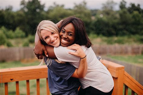 Friends Hugging And Smiling By Stocksy Contributor Leah Flores Stocksy
