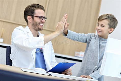 Little Boy In Clinic Having A Checkup With Pediatrician Stock Photo