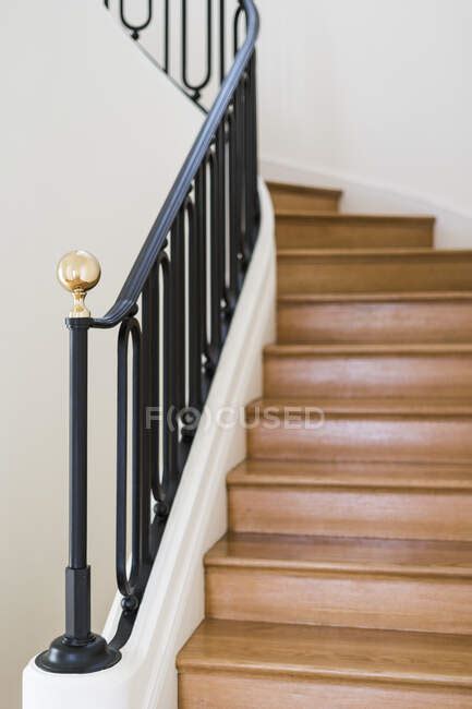 Solid Wooden Staircase With Black Railing In House With Light Interior