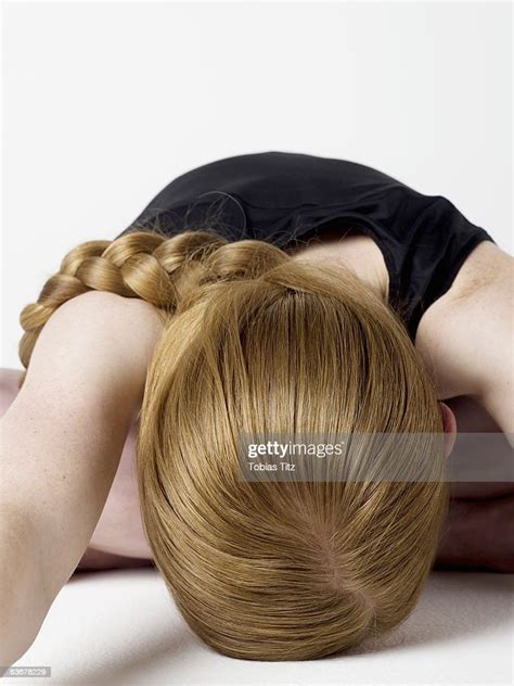A Young Woman Bending Over And Resting Her Head On The Floor Photo