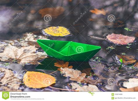 Autumn Time Paper Boat And Fallen Dry Leaves On The Water Surface
