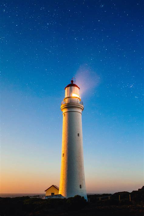 Lighthouse Beneath The Sky And Stars With Light On Image Free Stock