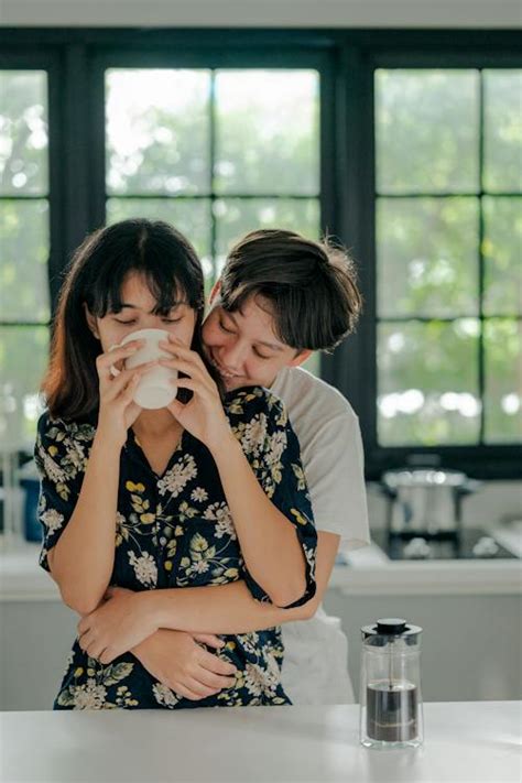 Woman Hugging Girlfriend Drinking Coffee From Behind · Free Stock Photo