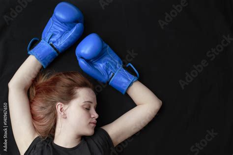 A Girl In Boxing Gloves Lies On The Floor With Her Eyes Closed In A