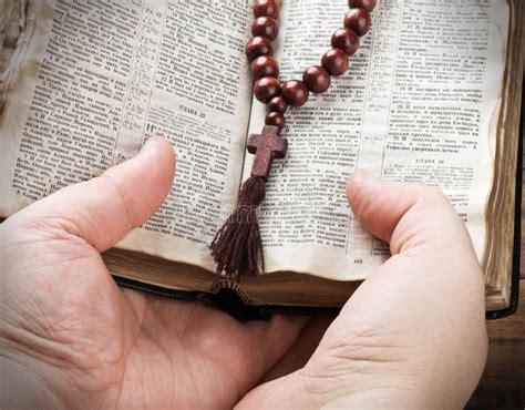 Hands Holding The Bible And Praying With A Rosary Stock Photo Image