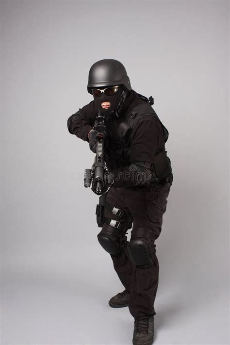 Swat Police Officer Pointing A Gun At The Camera Isolated On White