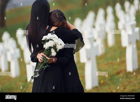 Embracing each other and crying. Two young women in black clothes
