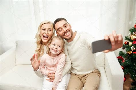Familia tomando selfie con smartphone en Navidad fotografía de stock