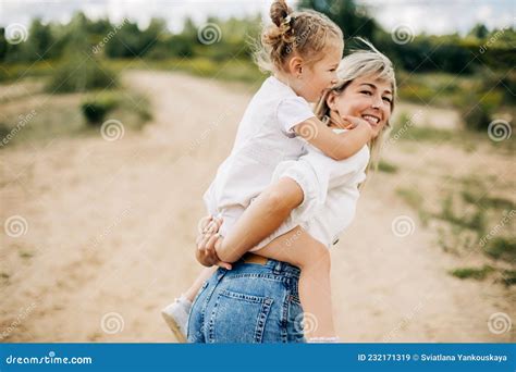 Uma Jovem Mãe Rola Sua Filha Nas Costas O Bebê Abraça Sua Mãe Imagem De Stock Imagem De Bonito