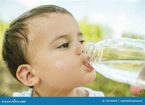 Headshot Of Adorable Toddler Boy Drinking Water From Plastic Bottle