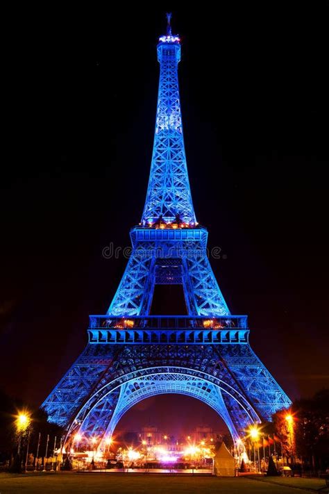 Eiffel Tower Glowing Blue Illuminated At Night In Paris France
