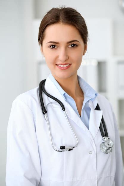 Premium Photo Young Brunette Female Doctor Standing With Clipboard