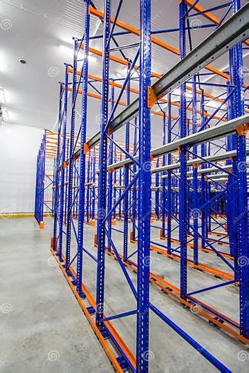Blue And Orange Metal Shelves For Storing Goods In A Large Warehouse