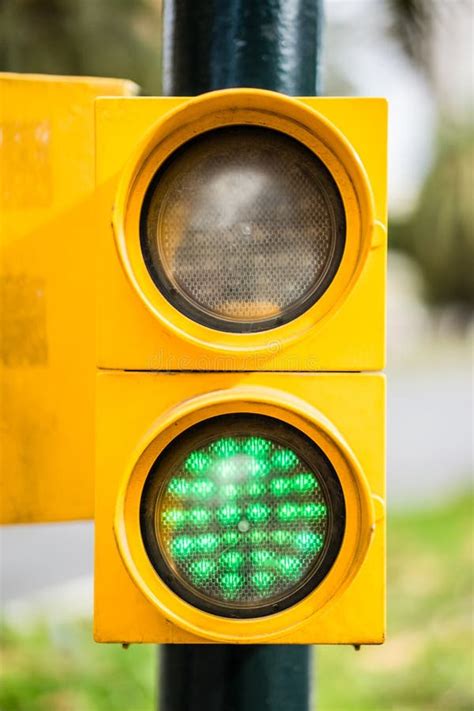 Vertical Closeup Shot Of A Yellow Traffic Light With An Illuminated