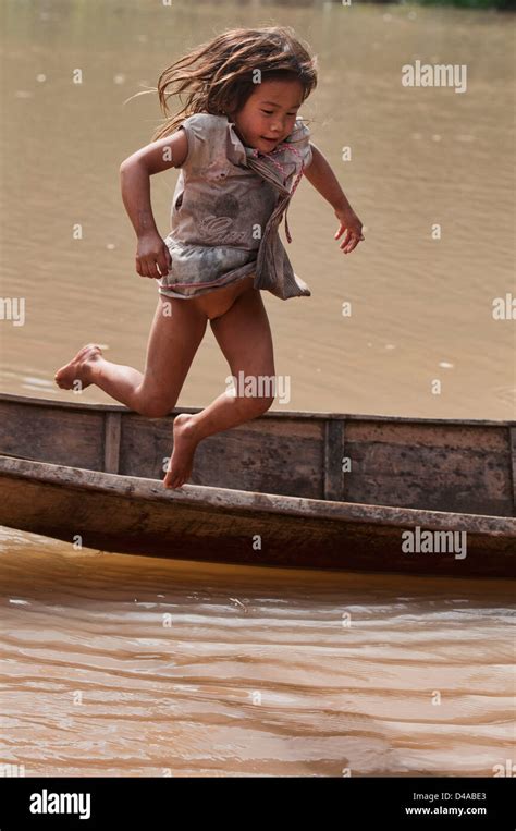 Chica Lanten saltando fuera de su canoa en el río Nam Ha Luang Nam Tha Laos Fotografía de