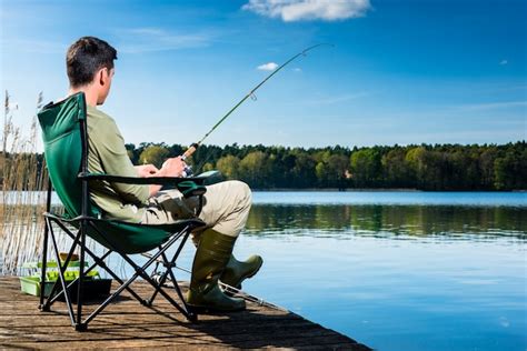 Premium Photo Man Fishing At Lake Sitting On Jetty