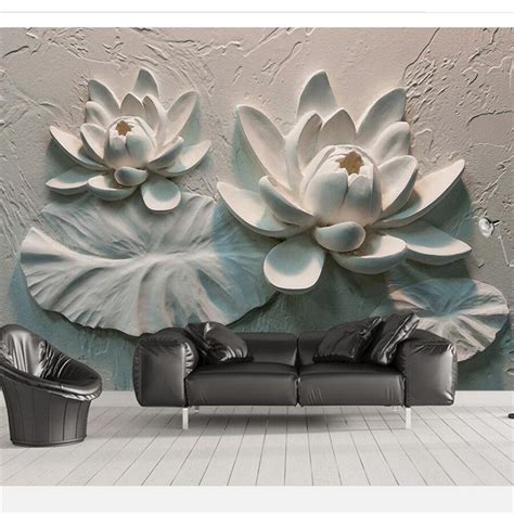 A Living Room With A Black Couch And Large White Flowers On The Wall