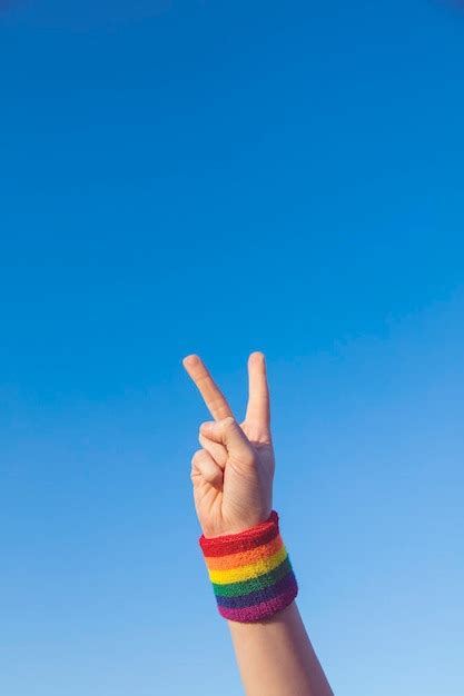 Premium Photo Gay Pride Concept Hand Making A V Peace Sign With Gay Pride Lgbt Rainbow Flag