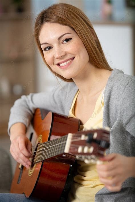 Una Hermosa Mujer Sonríe Mientras Toca La Guitarra Acústica Vector Fondos E Imagen Para Descarga