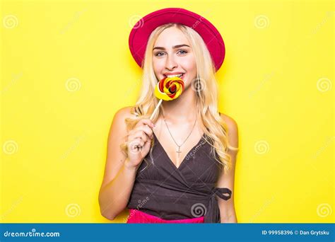 Attractive Woman In White Top With Lollipop In Hand On Yellow