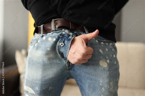 male hand sticking out of fly of his jeans and showing thumb up close up treatment of sexual