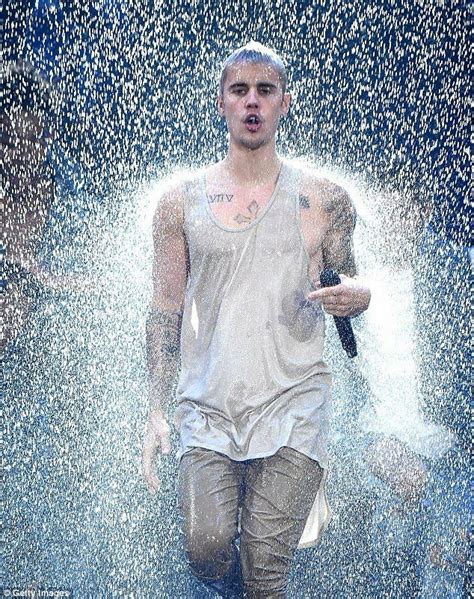 A Young Man Is Running Through Water Spraying From His Head And Arms As