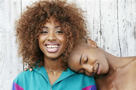 Bald Black Woman Leaning Head On Shoulder Of Friend Stock Photo