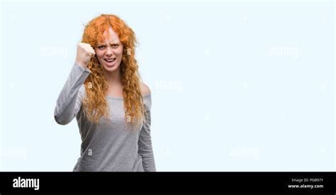 Young Redhead Woman Angry And Mad Raising Fist Frustrated And Furious