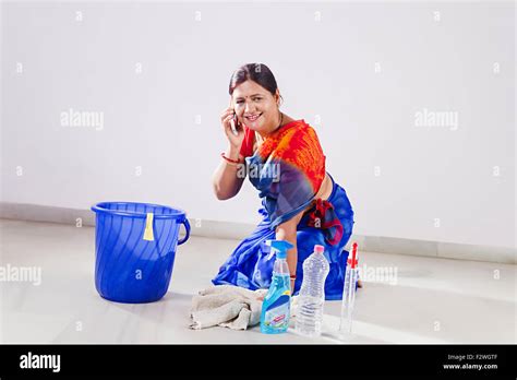 Indian Adult Woman Housewife Cleaning Floor And Talking Mobile Stock