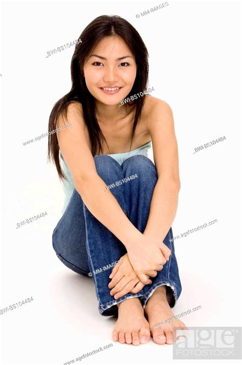 A Beautiful Young Asian Woman Sitting On The Floor Stock Photo