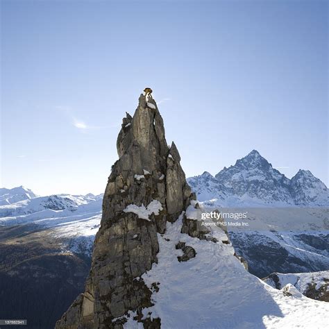 Climber Reaches Summit Of Snowy Pinnacle High Res Stock Photo Getty