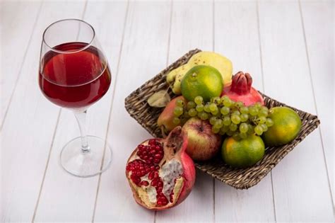 Free Photo Side View Of Black Grape Juice In Glass And Grapes In Bowl