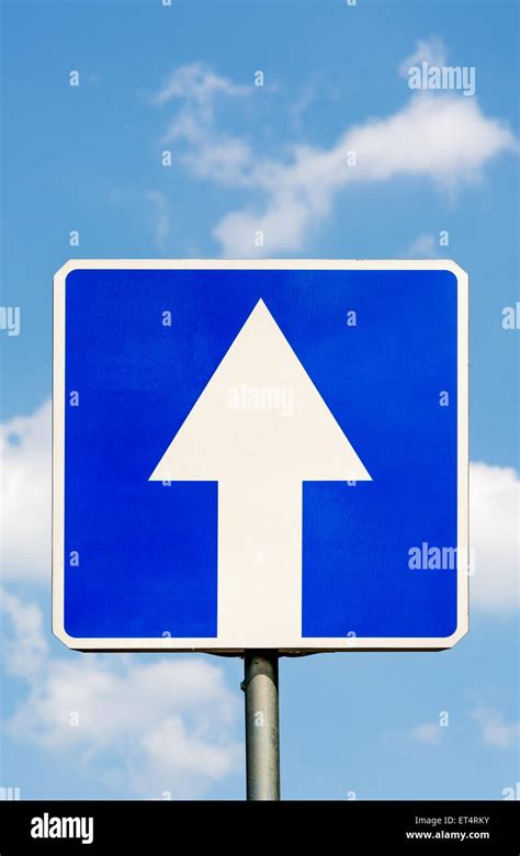 One Way Traffic Road Sign Against A Blue Sky And Clouds Concept The