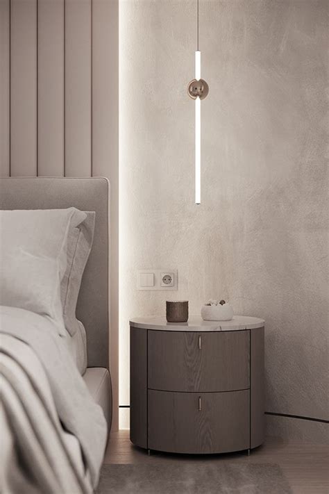 A White Bed Sitting Next To A Night Stand With A Lamp On Top Of It