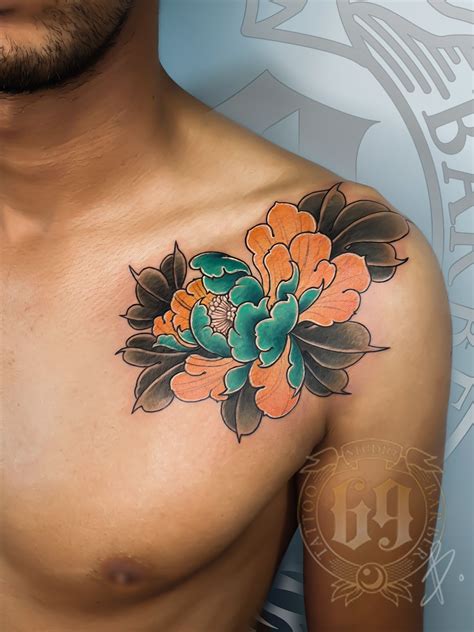 A Close Up Of A Mans Chest With An Orange Flower Tattoo On It