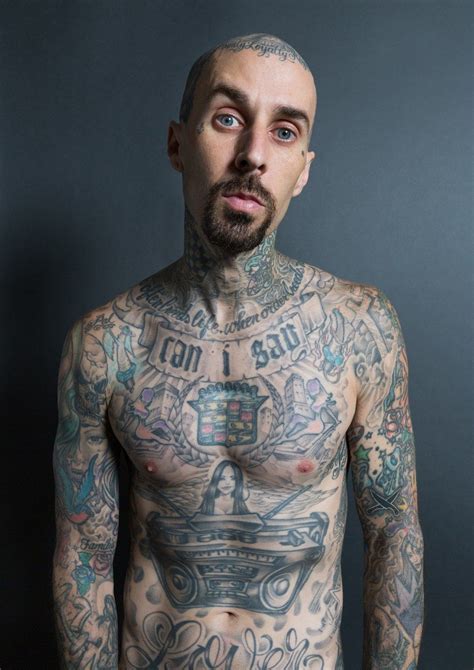 A Man With Lots Of Tattoos On His Chest And Chest Is Looking At The Camera