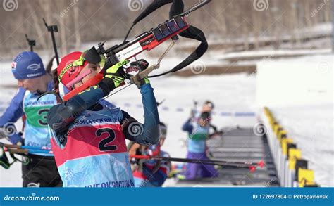 sportswoman biathlete aiming rifle shooting in standing position biathlete polina yegorova